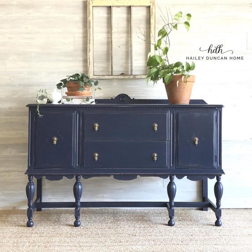 Navy painted buffet by Hailey Duncan Home. Buffet has some books and plants sitting on top.
